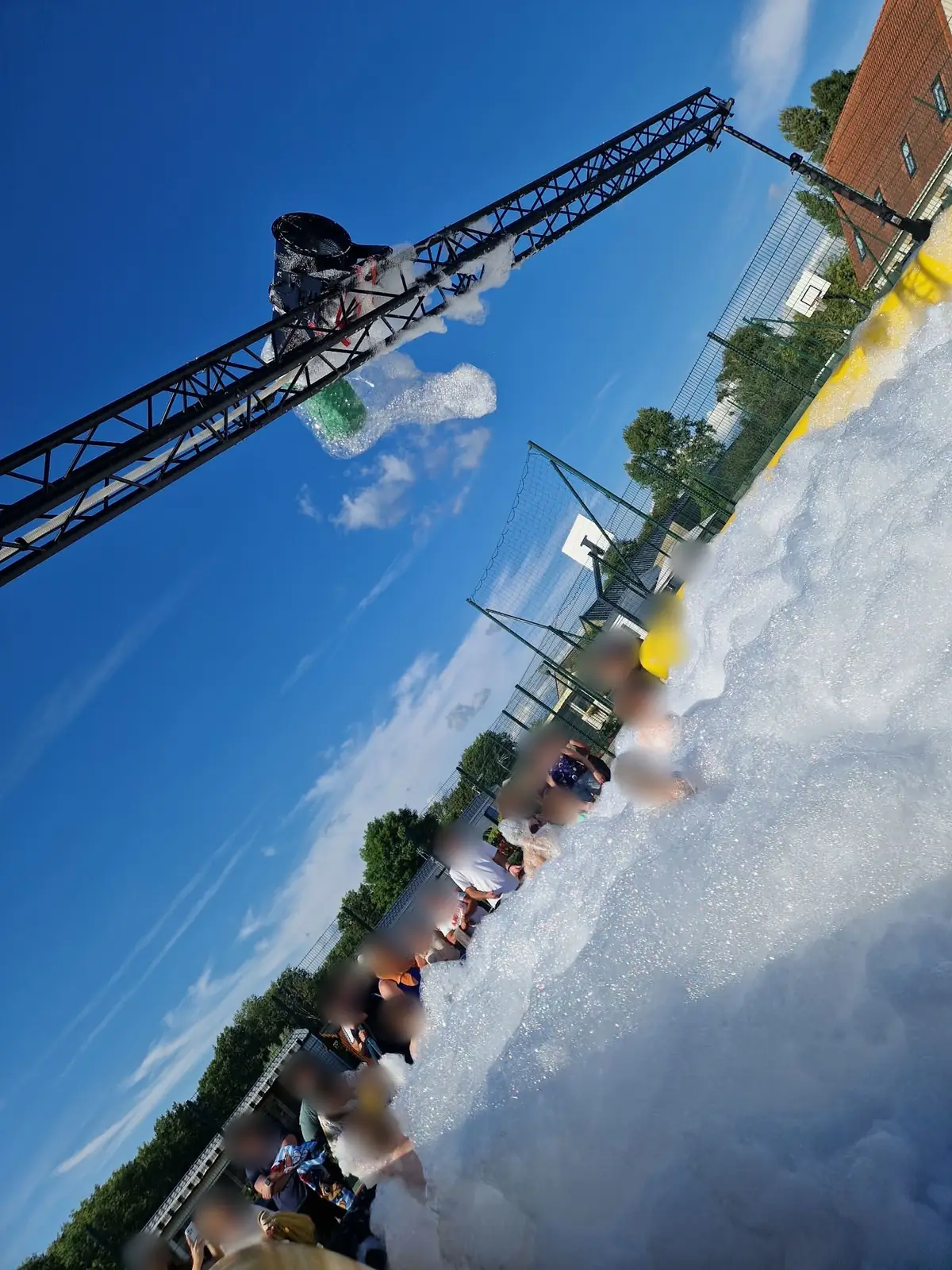 Machine à mousse cascade installée en hauteur sur une structure, déversant une mousse abondante au-dessus du public dans un bassin gonflable à Berck, dans le Pas-de-Calais