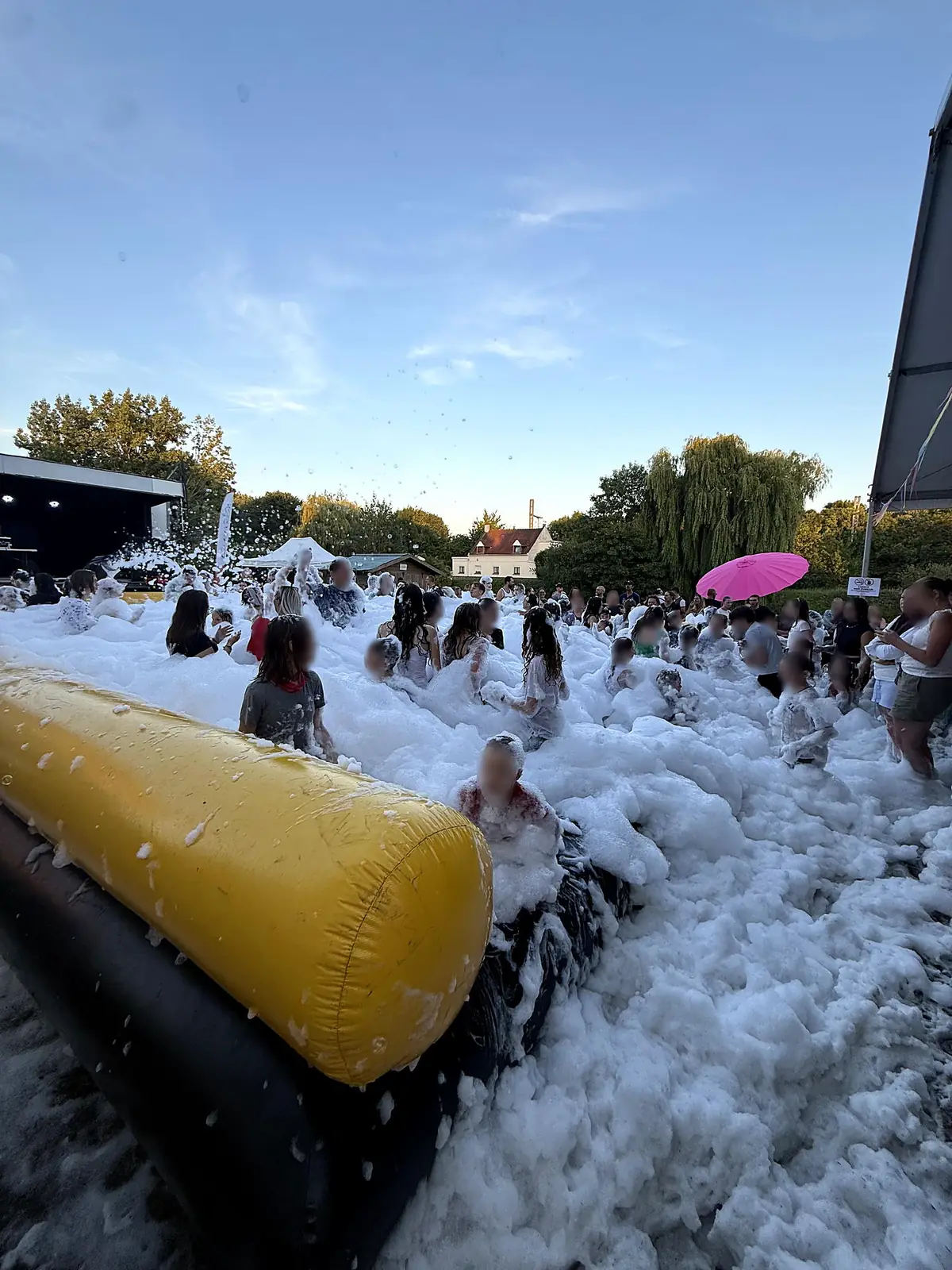 Mousse party de fête communale à La Bassée (Nord) Foule dans la mousse au coucher du soleil pendant la mousse party de la fête communale de La Bassée, dans le Nord